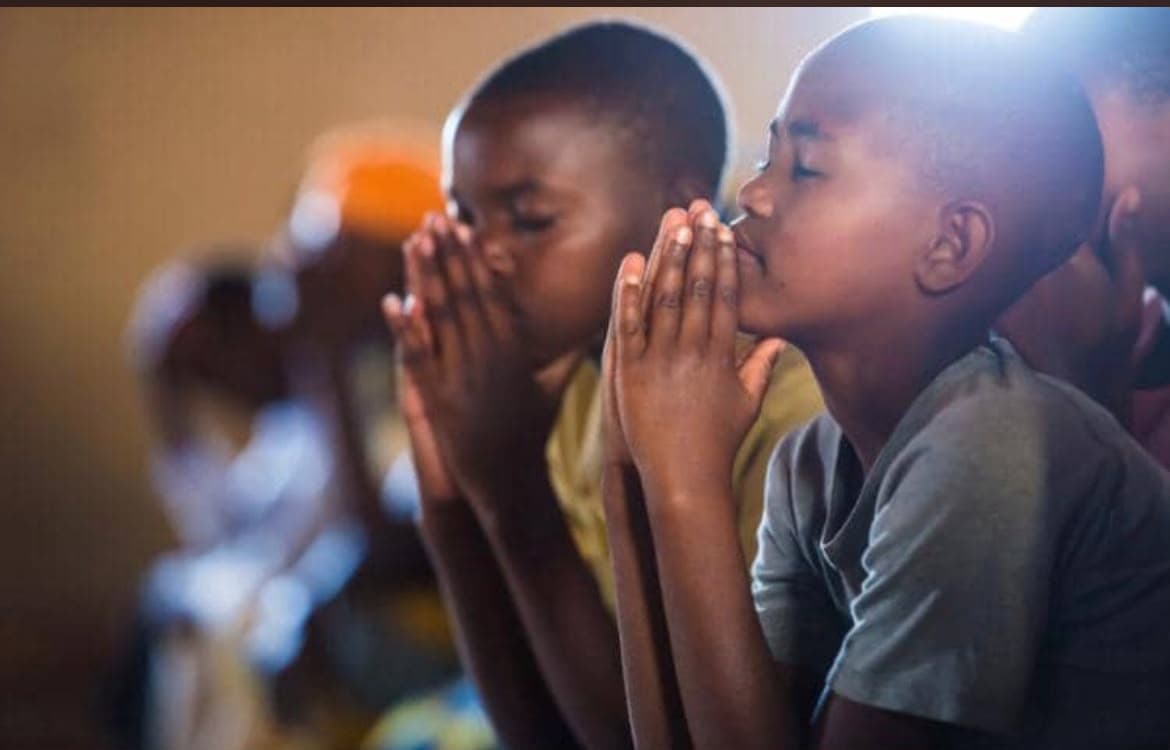 Two children praying with their hands together